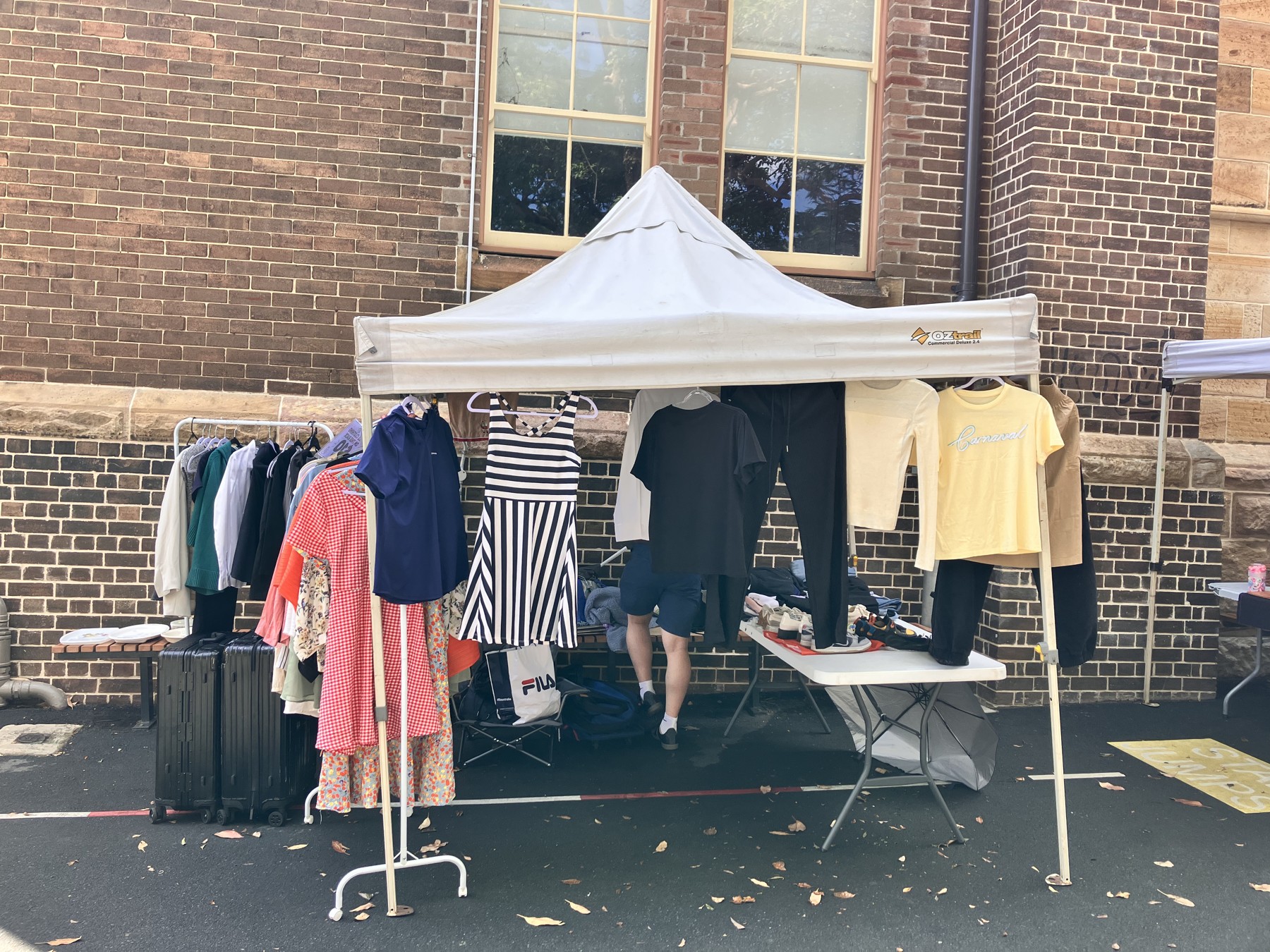 Our clothing stall outside the brick school building at Rozelle Market on 10 October 2026